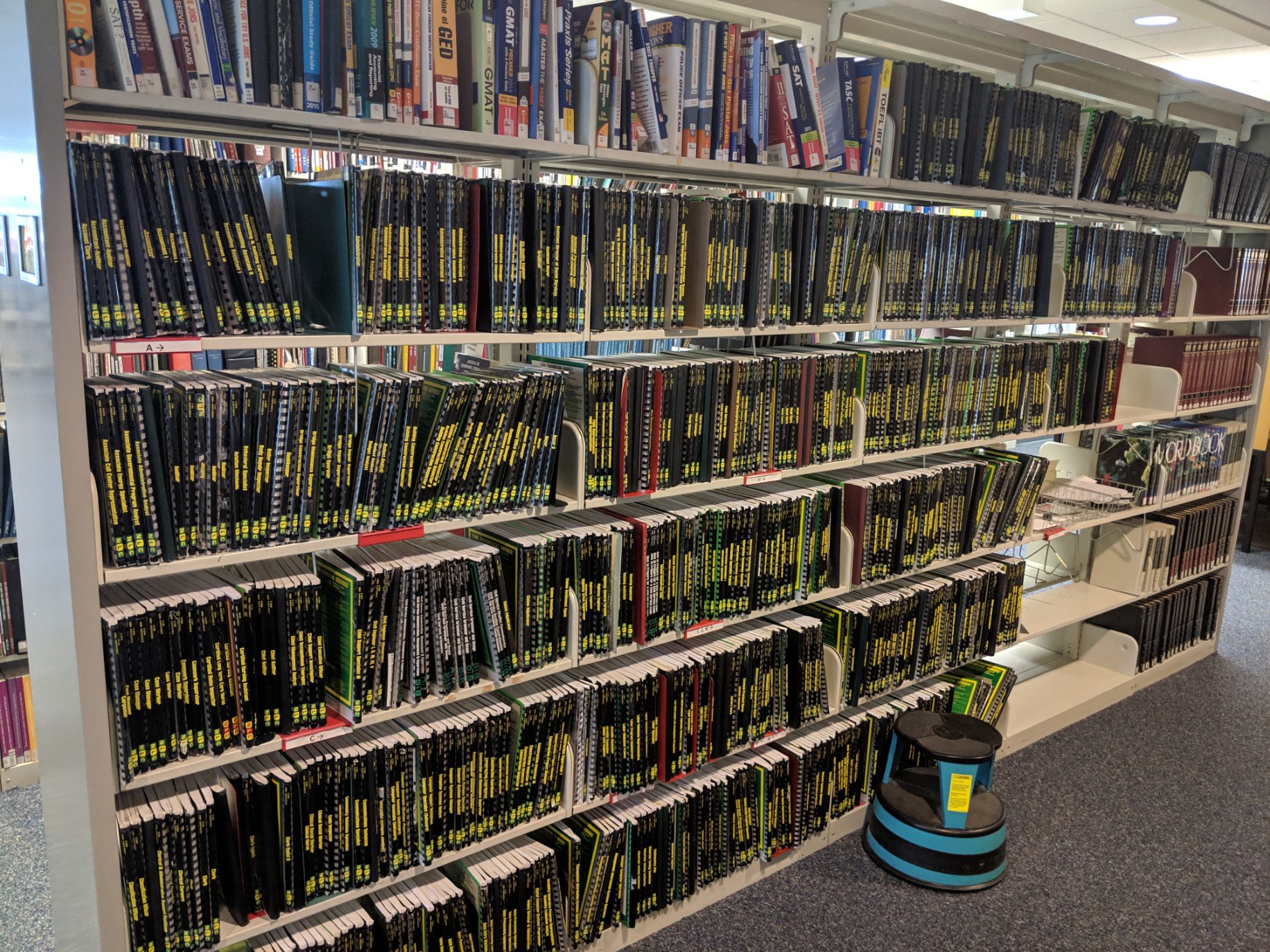 A collection of test books displayed on shelves in NJ State Library.